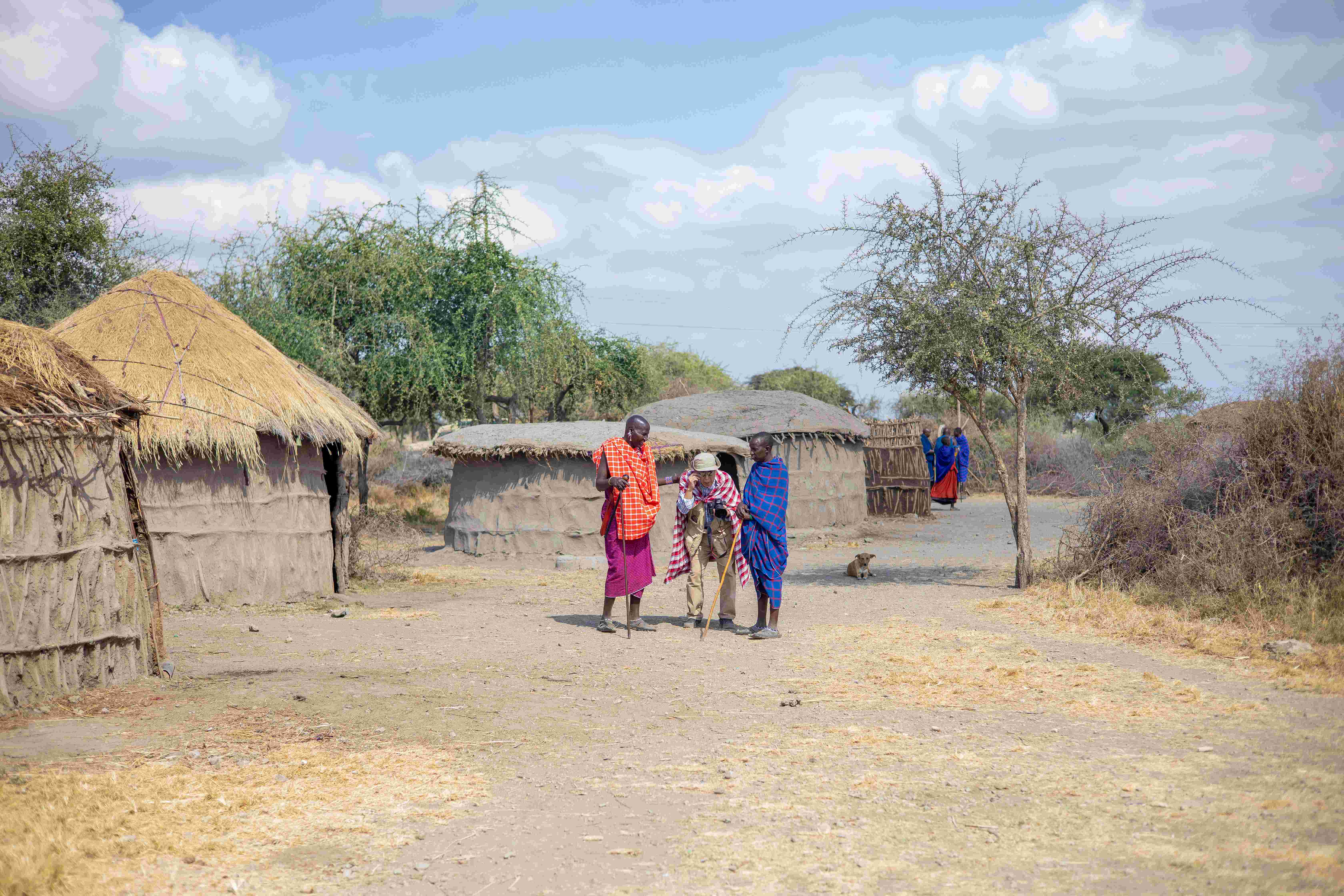 Travellers experiencing everyday village life in Tanzania with local community members